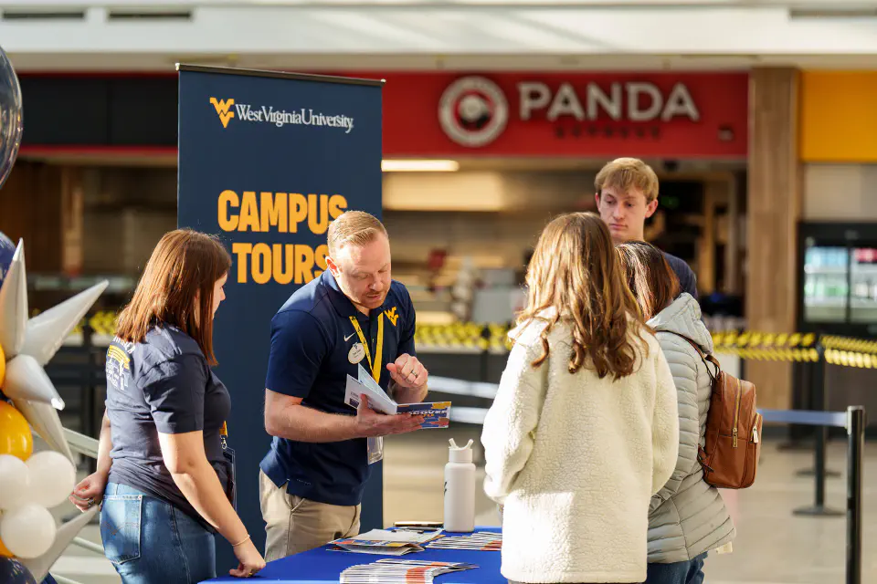 A West Virginia University representative is explaining campus tours to potential students.