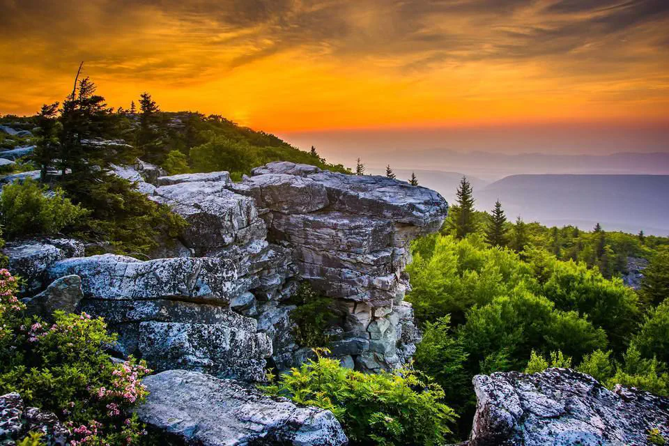 A breathtaking sunset paints the sky with vibrant colors over a rugged mountain landscape.